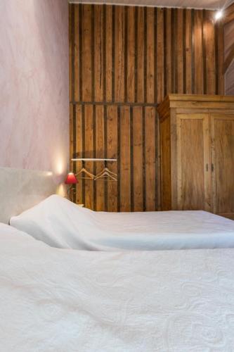a bedroom with a white bed and a wooden wall at Vieux chene in Sabres
