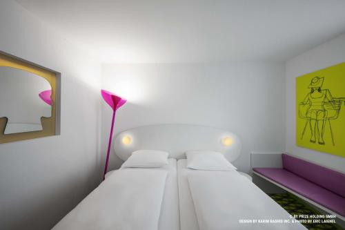 a small room with two beds and a lamp at Prize by Radisson, Bremen City in Bremen
