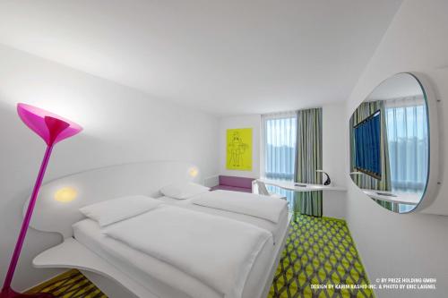a white room with a bed and a mirror at Prize by Radisson, Bremen City in Bremen