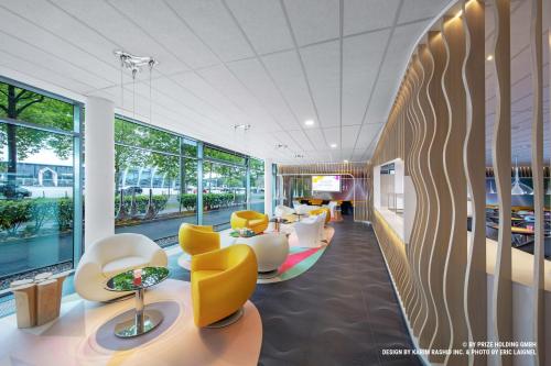 a waiting room with yellow and white chairs at Prize by Radisson, Bremen City in Bremen
