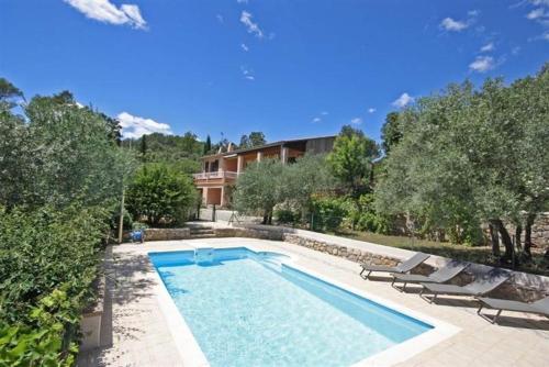 une piscine avec deux chaises et une maison dans l'établissement Mas de guili, au Thoronet