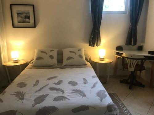 un lit dans une chambre avec deux lampes et un bureau dans l'établissement Mas de guili, au Thoronet