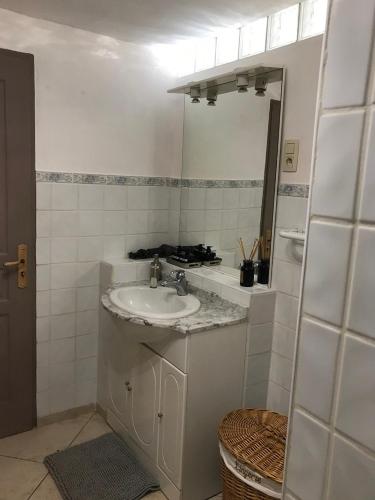 une salle de bain blanche avec un lavabo et un miroir dans l'établissement Mas de guili, au Thoronet