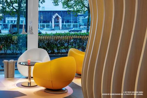 a room with three yellow chairs and a window at Prize by Radisson, Bremen City in Bremen