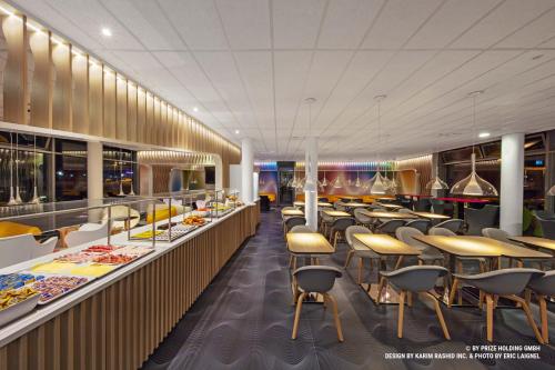 a restaurant with tables and chairs and a buffet at Prize by Radisson, Bremen City in Bremen