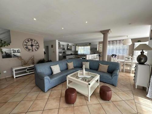 un salon avec un canapé bleu et une table dans l'établissement Villa dunisia, à Léon