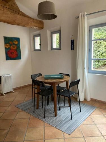 - une table et des chaises en bois dans une chambre avec fenêtre dans l'établissement Le petit mas, à La Cadière-dʼAzur