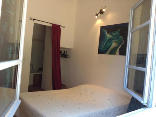 une petite chambre avec un lit et une fenêtre dans l'établissement Le petit mas, à La Cadière-dʼAzur