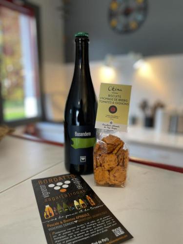 une bouteille de vin et une boîte de pain sur un comptoir dans l'établissement Gerezi ondoan, à Saint-Jean-le-Vieux