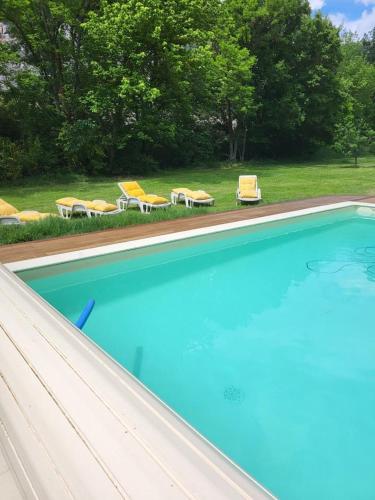 - une piscine avec 2 chaises et 2 chaises longues dans l'établissement Le moulin des rocs, à Rians