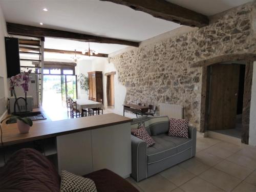 a kitchen and living room with a couch and a counter at La maison du becq in Saint-Lon-les-Mines