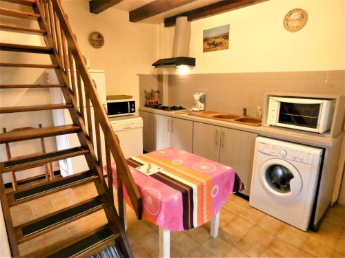 une cuisine avec un escalier et un lave-linge. dans l'établissement Le gemmeur, à Soustons