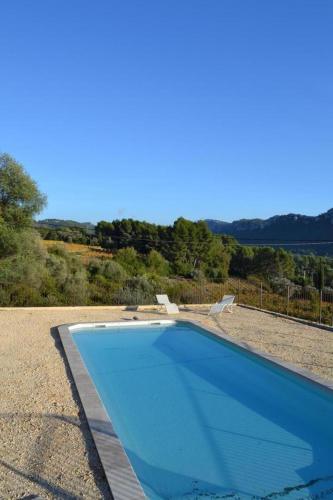 - une piscine bleue avec 2 chaises blanches dans l'établissement Cinsault, à La Cadière-dʼAzur