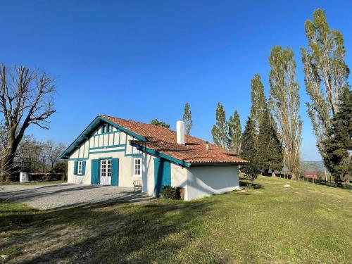 a small white and blue house with a yard at Trebuc in Labastide-Clairence
