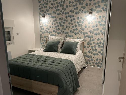 a bedroom with a bed with a green blanket at Maison pintoun in Heugas