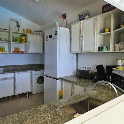 a kitchen with white cabinets and a white refrigerator at Villa Guadeloupe Saint François Accès Mer Piscine IGUANA BAY - Villa Zagadi in Saint-François