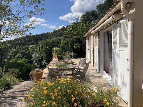 d'une terrasse avec une table et des chaises sur le côté de la maison. dans l'établissement Villa hortus mariae, au Thoronet