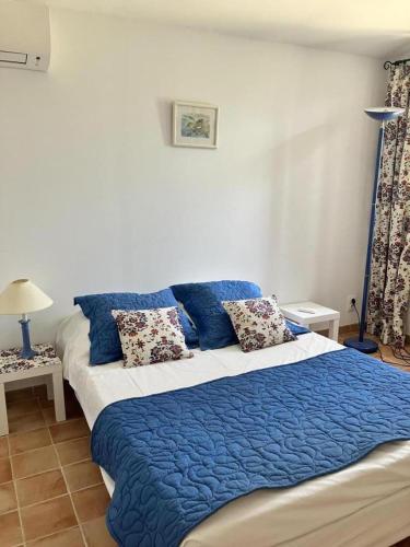 une chambre avec un grand lit avec des draps et des oreillers bleus dans l'établissement Gite 2 personnes les manoullieres, à Laouque