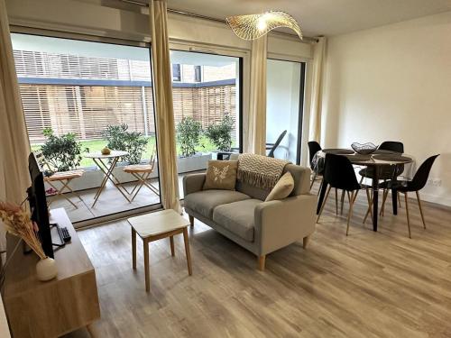 un salon avec un canapé et une table dans l'établissement L'appartement de l'ermitage, à Dax