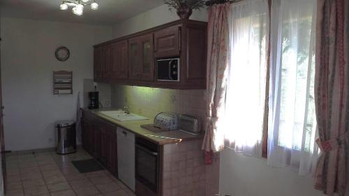 a kitchen with wooden cabinets and a sink and a window at Le font castellan in Bauduen