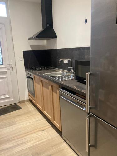 une cuisine avec un évier et une cuisinière four supérieur dans l'établissement Chez Bruno, à Senarpont