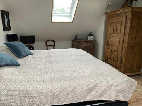 une chambre avec un grand lit blanc et une fenêtre dans l'établissement Chez Bruno, à Senarpont