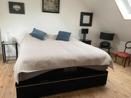 une chambre avec un lit avec des oreillers bleus dessus dans l'établissement Chez Bruno, à Senarpont