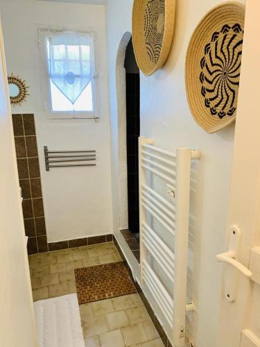 La salle de bains est pourvue d'une porte blanche et d'une fenêtre. dans l'établissement Gite 525 avec piscine, à Sainte-Maxime