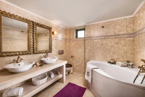 a bathroom with two sinks and a tub and a mirror at Luxury Villa Golden Crest with private swimming pool in Hersonissos