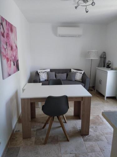 une table avec une chaise dans un salon dans l'établissement L'amandier, à Moissac-Bellevue