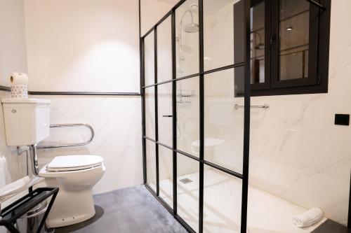 a bathroom with a toilet and a glass shower at Boutique Hotel Casa Cánovas in Cádiz