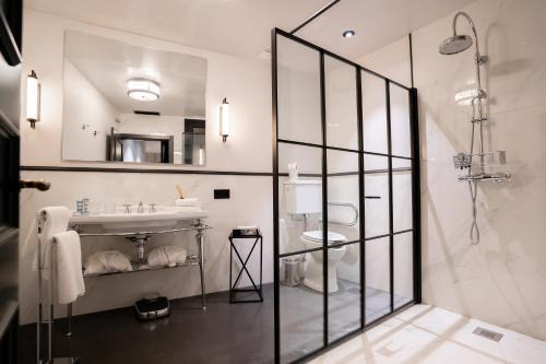 a white bathroom with a sink and a shower at Boutique Hotel Casa Cánovas in Cádiz