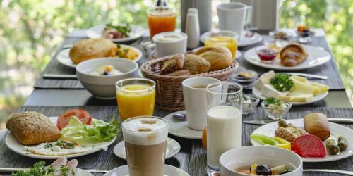 a table with plates of food and glasses of orange juice at PLAZA INN Stuttgart Airport Messe in Filderstadt