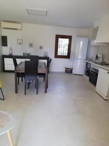 Il comprend une cuisine et une salle à manger avec une table et un réfrigérateur. dans l'établissement L'audiberte, à Laouque