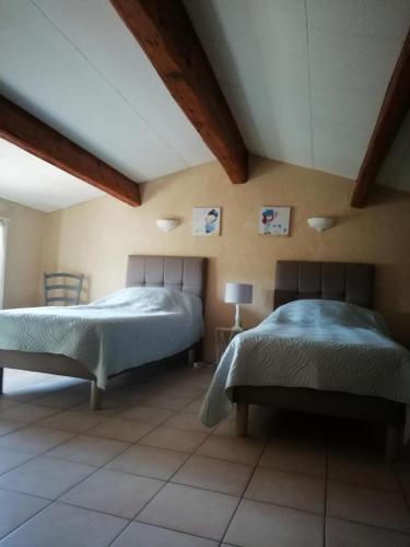 une chambre avec deux lits dans une pièce dans l'établissement L'audiberte, à Laouque