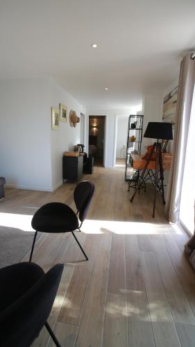 a living room with chairs and a piano on a wooden floor at Bella Vista Hôtel, Suites & Maisons in Porticcio