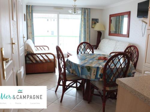 une cuisine et une salle à manger avec une table et des chaises dans l'établissement Appartement cosy près de la plage avec balcon, parking et animaux admis - FR-1-482-9, à Fort-Mahon-Plage