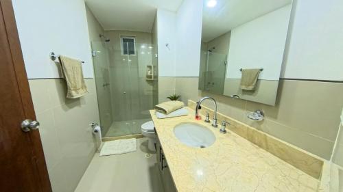 a bathroom with a sink and a toilet and a mirror at Paraíso Costero Morros Vitri La Boquilla familiar 4 personas in Cartagena de Indias