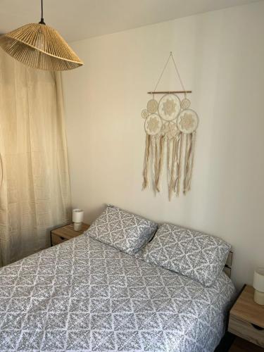 une chambre avec un lit et une horloge au mur dans l'établissement Charmant Appart clim 6 pers, Sorgues Vaucluse 1, à Sorgues