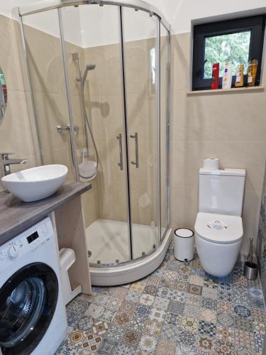 a bathroom with a shower and a washing machine at Jaunmāriņi in Liepāja