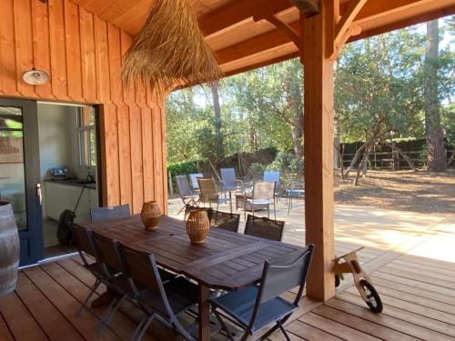 une table et des chaises en bois sur une terrasse en bois dans l'établissement Grande maison idéale pour familles, à Lège-Cap-Ferret