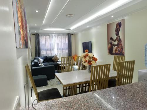a living room with a table and chairs at 3 Bedroom Furnished Apartment in Athi River Pridelands Greatwall Gardens phase 4 in Nairobi