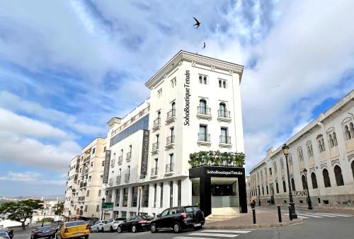a white building with cars parked in front of it at Soho Boutique Tetuán in Tetouan