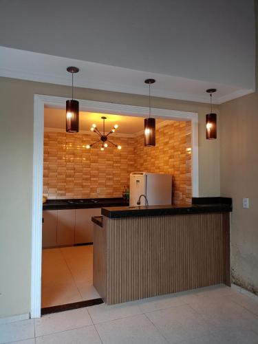 a kitchen with a counter with a refrigerator on a brick wall at Sítio Vovô Erasmo in Itarema