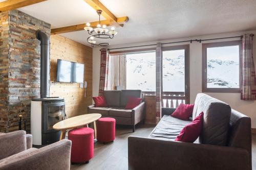 a living room with a couch and a fire place at Résidence Les Balcons de Val Thorens & Spa in Val Thorens