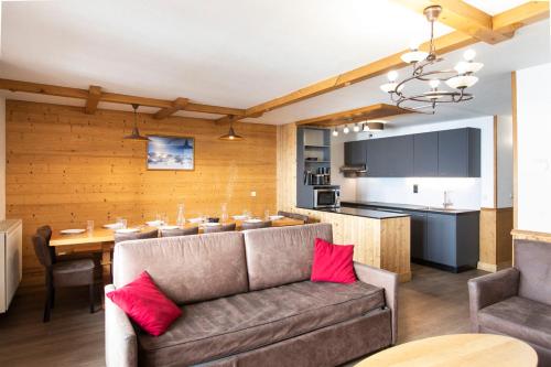 a living room with a couch and a dining room at Résidence Les Balcons de Val Thorens & Spa in Val Thorens