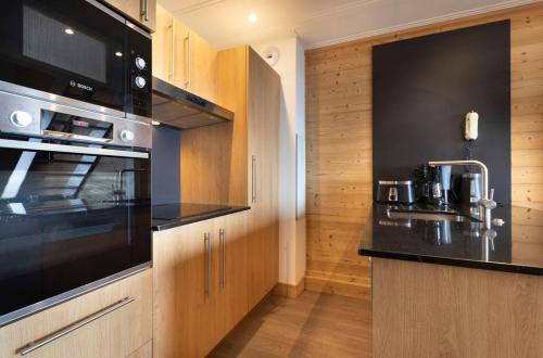 a kitchen with a sink and a stove top oven at Résidence Les Balcons de Val Thorens & Spa in Val Thorens