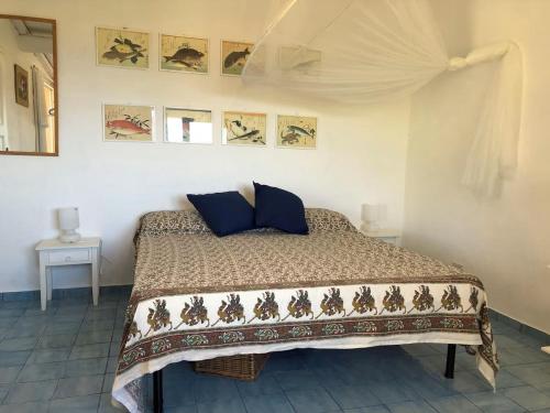 a bedroom with a bed with blue pillows on it at Splendid cottage on Tuscan Sea in Porto Santo Stefano
