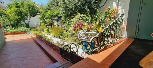 a wrought iron fence with flowers and plants at Garden Guest House in Tirana