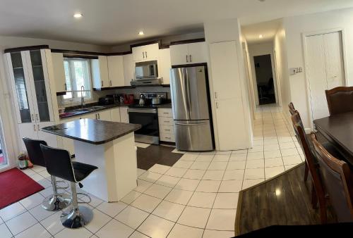 a kitchen with a refrigerator and a table and chairs at Motel LA RÉFÉRENCE in Trois-Rivières